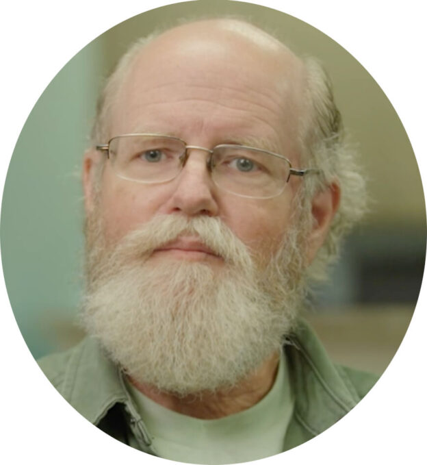Elderly man with glasses and white beard.