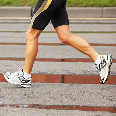 A person is walking on the street in their running shoes.