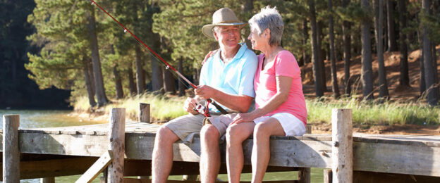 Senior couple fishing on a wooden dock.