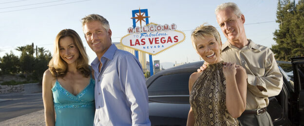 Group posing by Las Vegas welcome sign.